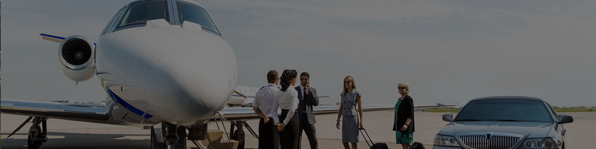 Business travelers receiving a VIP airport transfer service, walking from a private jet to a luxury limousine on the tarmac in Istanbul.